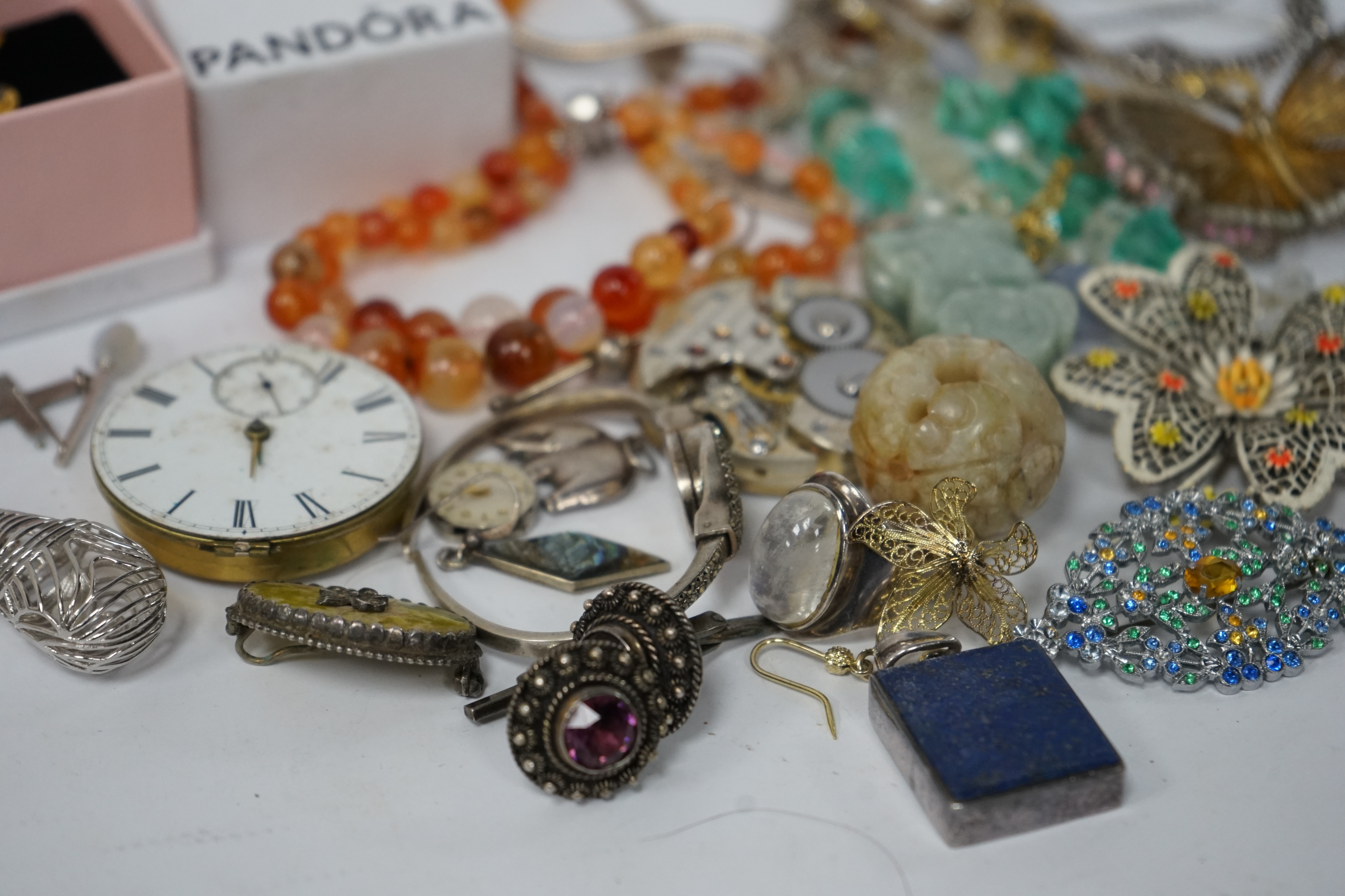 A small quantity of assorted jewellery and other items including a filigree butterfly brooch, a 925 and labradorite ring, an agate bead necklace, pocket watch movements, etc. Condition - poor to fair
